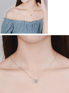 Detail showing two necklaces with crown and cylinder pendants worn by a model