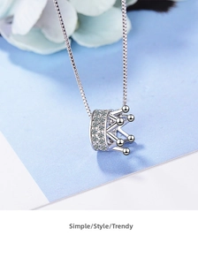Detail view of a silver crown pendant necklace with pavé-set sparkling cubic zirconia