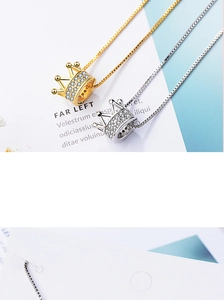 Close-up of elegant crown necklace pendants with sparkling rhinestones in gold and silver