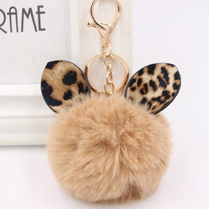 Close-up of fluffy light brown faux fur keychain with leopard print ears and gold clasp
