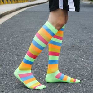 Unisex striped athletic crew socks with colorful rainbow pattern on outdoor pavement