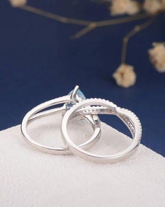 Macro shot of silver ring set featuring a pear-shaped light blue sapphire and pave diamonds