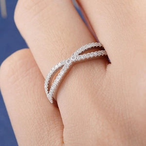 Close-up of model wearing a cross-over silver ring with sparkling micro-pave crystals