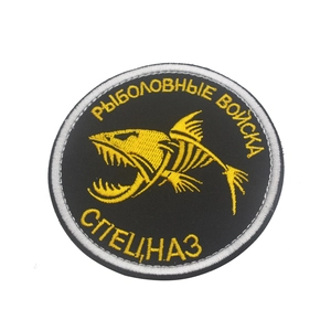 Close-up of yellow fishbone embroidery on black tactical patch with Russian text