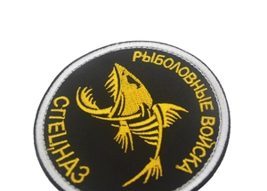Macro shot of circular tactical embroidery patch with Russian text and hook and loop backing