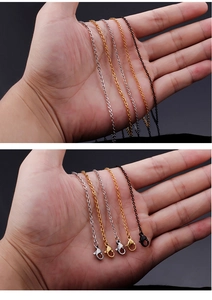 Close-up of assorted stainless steel O-chains in gold, silver, and black with lobster clasps