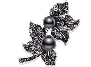 Detail of vintage gun black leaf brooch with marcasite accents and dark grey pearls