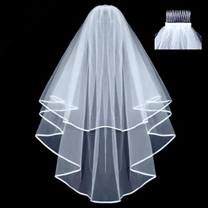 Close-up of white double-tier wedding veil with satin edge and metal hair comb detail