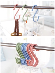 Macro shot of colorful plastic S-hooks hanging on a metal rod in a bright home setting