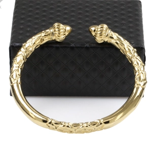 Close-up of a detailed 18K gold-plated pumpkin motif bangle on a black jewelry box
