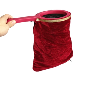 Red velvet magic change bag with golden trim and a durable red plastic handle for stage