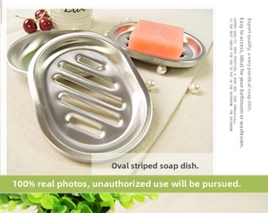 Close-up of oval stainless steel soap dish with drainage slots and luxury pink soap bar