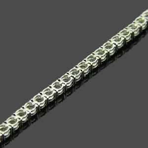 Macro detail of 5mm silver micro-pave tennis bracelet with clear zircon stones on black background
