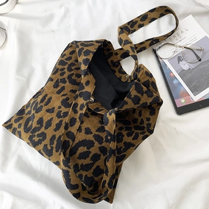 Detail of leopard print corduroy bag showing magnetic clasp, black lining and strap