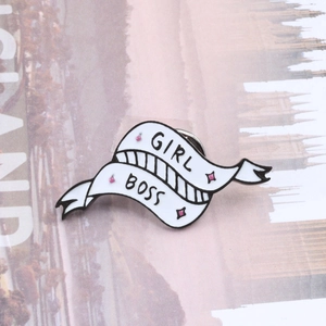 GIRL BOSS enamel brooch with vintage tattoo banner design on a fashion magazine background