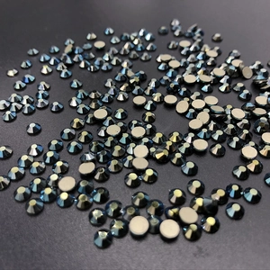 Macro shot of dark blue faceted flatback rhinestones with metallic luster on black background