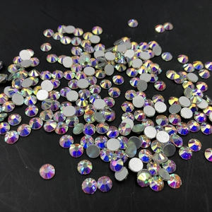 Detailed view of scattered iridescent round rhinestones with flat silver foil backing