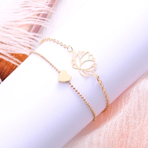 Ensemble de bracelets dorés avec breloques lotus et cœur sur dentelle élégante