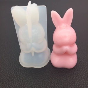 Detail of bunny praying silicone mold with pink resin rabbit model on dark background