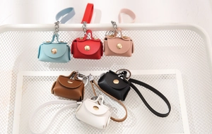Mini PU leather coin purse keychains in six colors displayed in a white wire basket