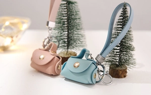 Close-up of pink and blue PU leather mini coin purse keychains with metallic buckles
