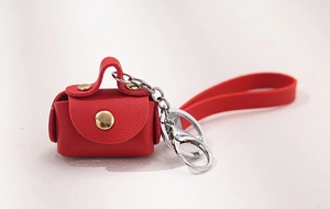 Detail of red lychee grain leather mini coin purse with gold snap and silver keychain