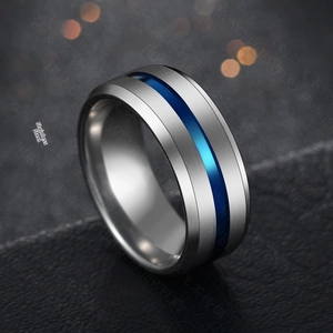 Macro shot of brushed silver steel ring with blue grooved center on leather background