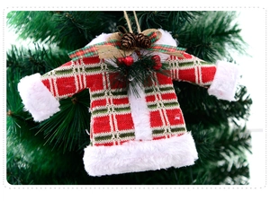 Close-up of a festive plaid Christmas sweater ornament with pine cones on a tree