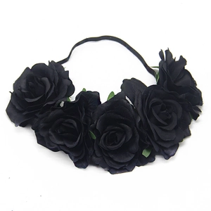 Close-up of five black artificial roses on an elastic headband for bridal or party wear