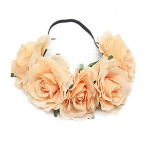 Detailed top view of peach artificial roses on a black elastic headband for festivals