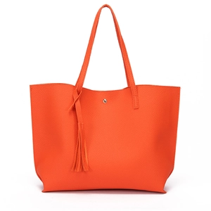 Detail of orange tote bag showing litchi grain texture and stylish hanging tassels