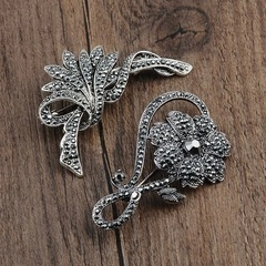 Macro detail of retro alloy marcasite brooches in floral and feather designs