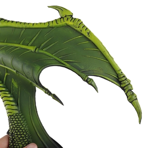 Close-up of green dragon wings with realistic scale texture and skeletal spikes detail