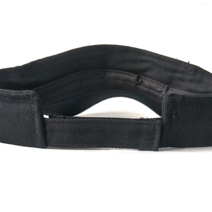Detail of adjustable velcro strap on the back of a black cotton sun visor hat