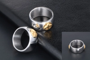 Detail view of titanium steel rings with golden bird motif on black leather