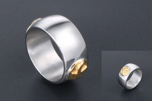 Detailed macro shot of a silver titanium steel ring featuring a gold cross inlay design