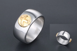 Detailed view of silver titanium steel ring featuring a golden bird crest on the wide surface