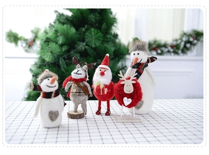 Detailed view of handmade Christmas felt dolls including snowman and reindeer on wood base
