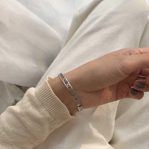 Close-up of S925 sterling silver Roman numeral cutout bracelet worn by a model
