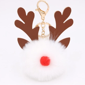 Detail of white fluffy reindeer keychain with brown antlers and a golden metal clasp