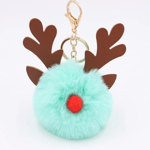 Close-up of mint green reindeer pompom keychain with brown antlers and gold metal clasp