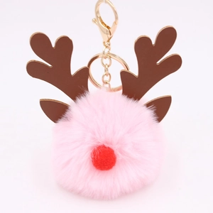 Macro detail of a pink plush reindeer ball keychain with brown antlers and gold metal clasp