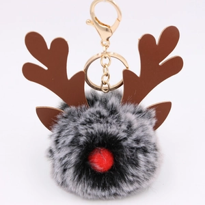 Detail of Christmas reindeer plush keychain with grey fur pompom and golden metal clasp