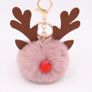 Detail of pink faux fur pompom keychain with reindeer antlers and golden clasp
