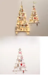 Detail of wooden branch Christmas tree with LED lights and festive ornaments on wall