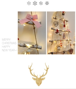 Detail of wooden Christmas tree wall hanging with warm LED lights and pink bows
