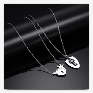 Detailed close-up of silver stainless steel heart lock and key couple necklace set