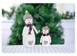 Detail of wool felt snowmen with striped scarves and grey heart accents for Christmas
