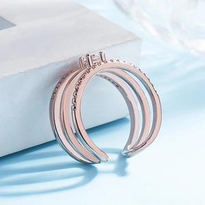 Macro shot of rose gold triple layered open ring featuring delicate clear gemstone accents