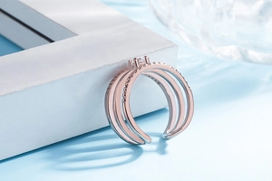 Close-up of rose gold and silver triple-layered open ring with sparkling diamond details